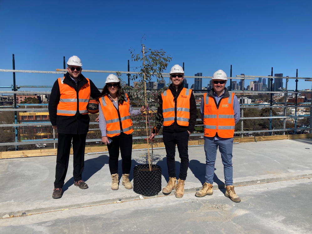 Development Victoria staff pose in front of the ceremonial tree on top of the Fitzroy Gasworks building